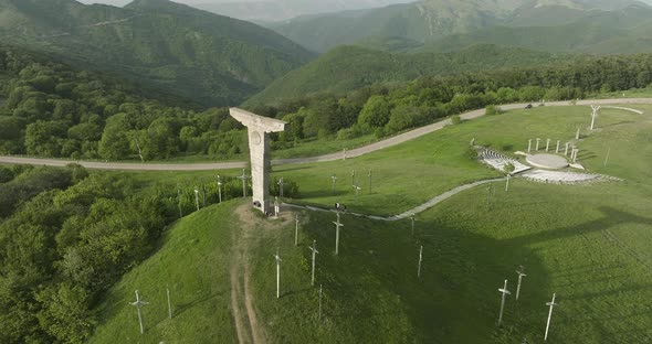 Arc aerial shot of Didgori Valley magical landscape and a memorial monument. alt