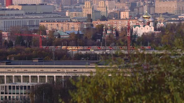 Modern Electric Passenger Train Moving in the Center of Moscow in Late Autumn alt