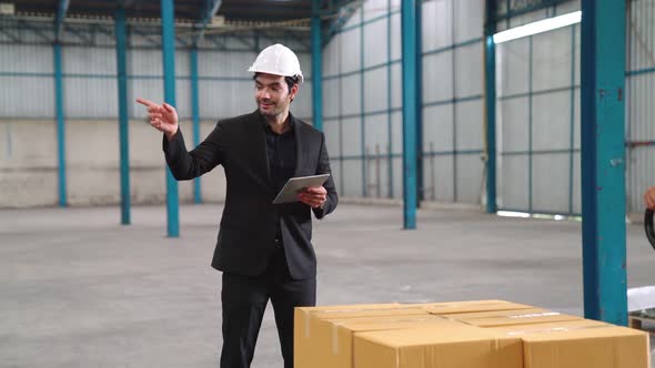 Factory Workers Deliver Boxes Package on a Pushing Trolley in the Warehouse alt