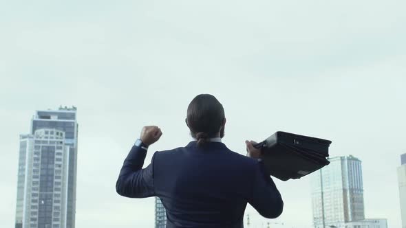 Handsome Man in Suit Raising Hands in Winner Gesture and Turning to Cam, Success