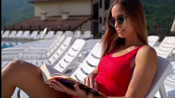 Hotel Guest Reading a Book at Poolside alt