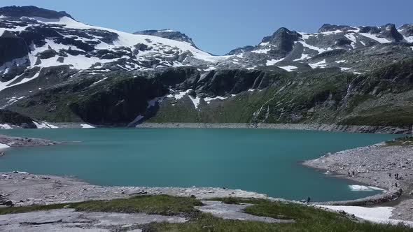 Flying towards a beautiful blue lake with snow and ice in the Austrian Alps, Uttendorf Weissee alt