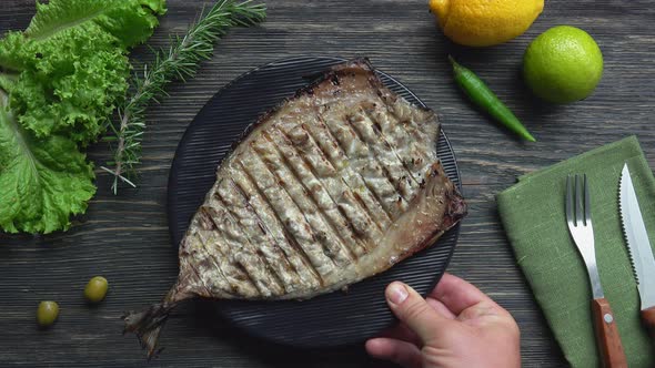Top View of the Black Plate with a Delicious Grilled White Mackerel Fish alt