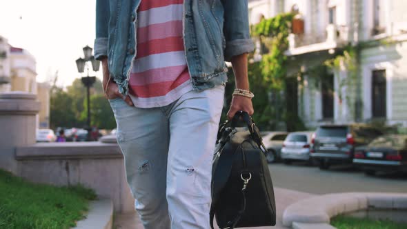 Close Up Shot of Young Stylish Handsome Man with Bag Walking in Old City Center Slow Motion alt
