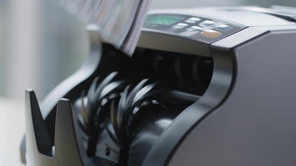 Closeup shot of money counting machine with 100 dollar bills.