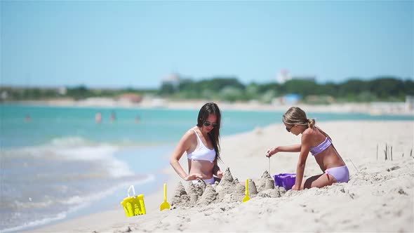 Family of Mom and Girl Making Sand Castle at Tropical White Beach