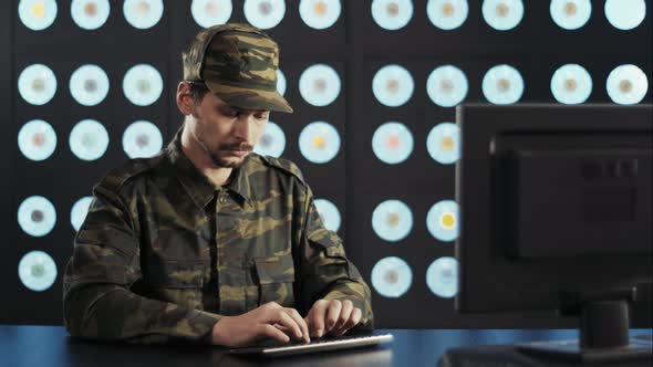 Serious Bearded Mature Man Wearing Military Clothes Types on Keyboard in Office