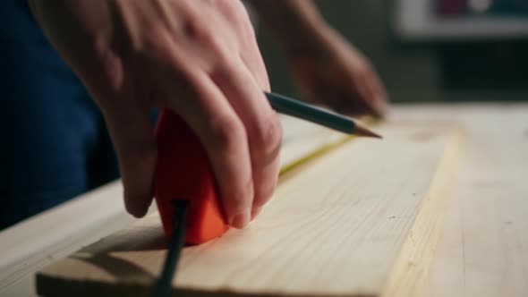 Woman Builder Using Roulette Wheel and Drawing Mark on Wooden Board Closeup alt