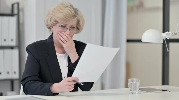 Old Businesswoman Disappointed By Loss on Documents alt