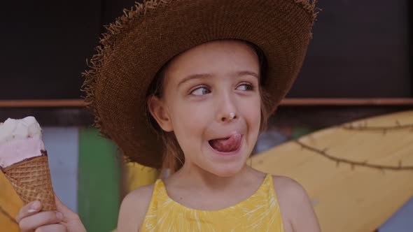 Little Girl in Straw Hat Eating Ice-cream Outdoors Street. Summer Portrait