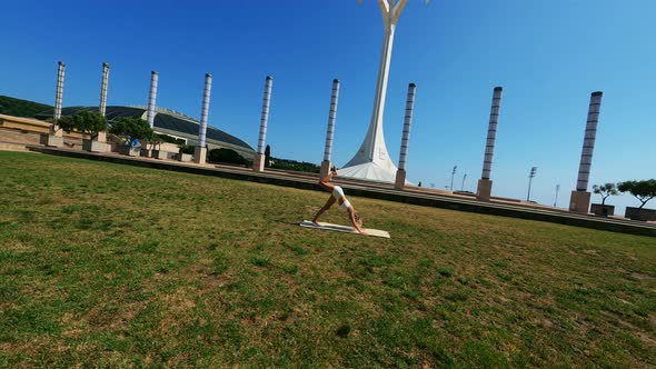 Girl in White Dress Doing Stretching Exercises on the Grass at Sunny Day