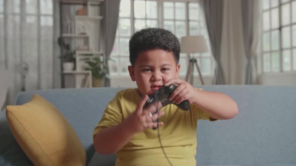 Asian Little Boy Gamer Hands Up Moving While Winning Video Game alt