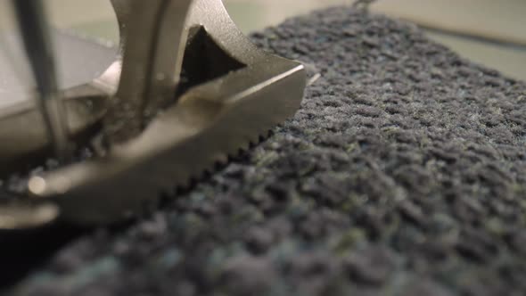 Presser Foot of a Sewing Machine with Needle Dipped in Gray Woolen Fabric alt