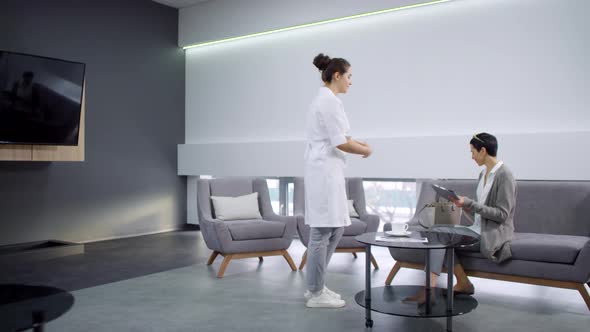 Cheerful Female Dentist Asking Patient to Follow Her alt