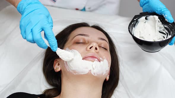 Doctor Cosmetologist or Dermatologist Making Face Mask in Cosmetology Salon alt