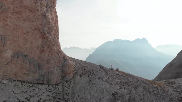 Slider Shot of Man Standing on Rock in Front of Langkofel Mountain in Dolomites Italy