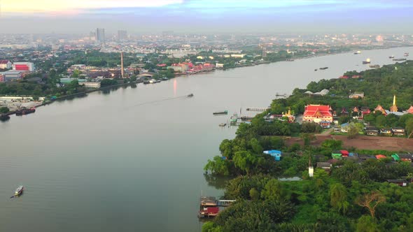 4k aerial view drone of refinery oil petroleum production factory with river reflecting surface sunr alt