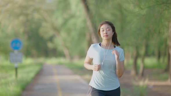 Asian cute girl She was jogging in the morning in the garden and the sun was shining, 4k resolution. alt
