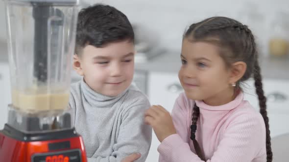 Joyful Middle Eastern Brother and Sister Having Fun in Kitchen Touching Noses and Laughing alt