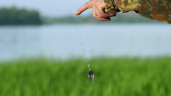 Fisherman Holds a Bait and a Bait on the Line, They Shine alt