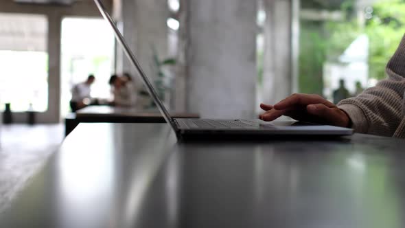 Closeup a woman working and touching on laptop computer touchpad on the table