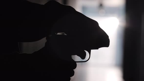 Silhouette of Man Reloading Handgun and Running