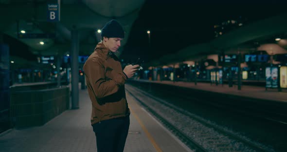 Midnight Commuter Wait for Train on Dark Platform alt