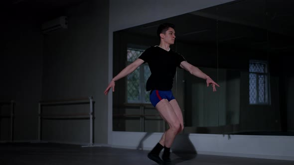 Concentrated Caucasian Young Man Performing Ballet Leaps Rehearsing in Studio Indoors alt