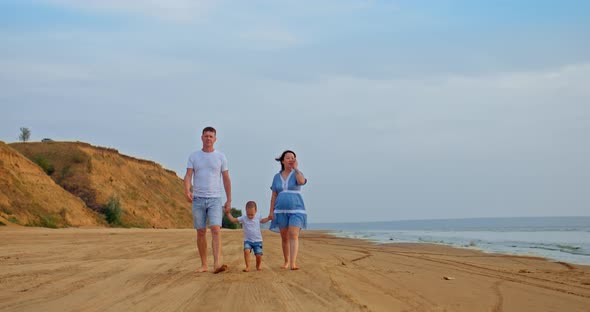 Happy Family Walks Along the Seashore