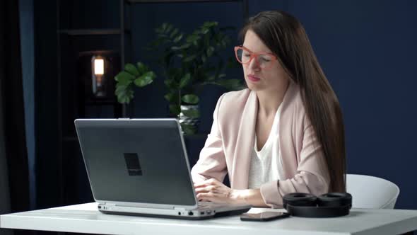 Exhausted Young Woman at Office Desk Working Late at Night
