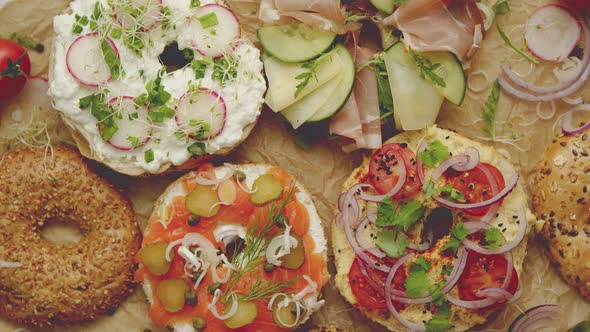 Circular Bread Bagel Sandwich Served with Various Toppings. Samlon, Ham and Cheese, Cottage, Hummus alt