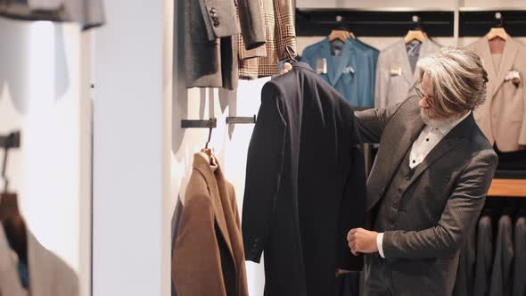 Man Chossing Clothes at Men's Wear Store alt