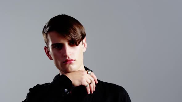 Androgynous man posing against grey background alt