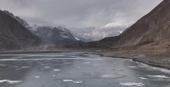 Aerial view, flying directly on a drone over the frozen Lake Karakoram Highway, Hunza Valley In Gilg alt