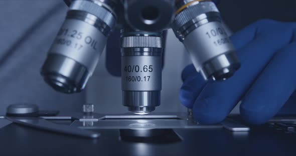 Sample Slide and Microscope with Metal Lens at Laboratory. alt