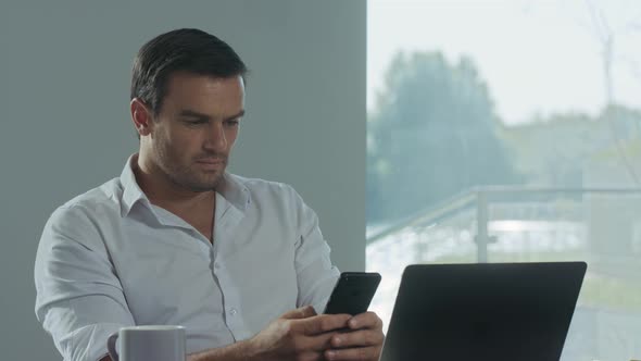 Business Man Looking Mobile Phone at Work Place. Concentrated Man Having Break alt