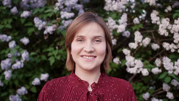 Face young woman close up. Portrait of attractive girl.Woman standing in the city streets in summer. alt