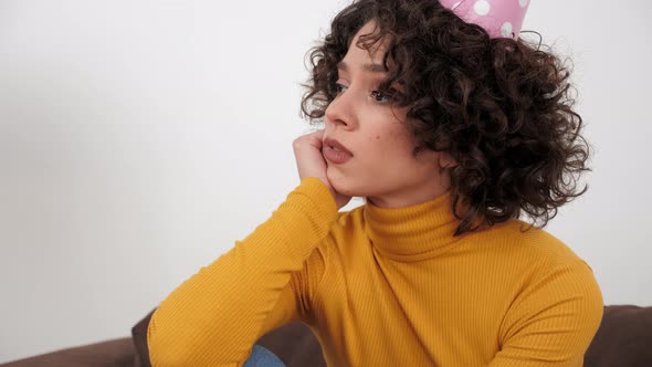 Upset Woman in Party Hat Looking Away Celebration Holiday Birthday Alone at Home alt