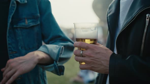 Close up of unrecognizable man holding a disposable cup with beer.  Shot with RED helium camera in 8 alt