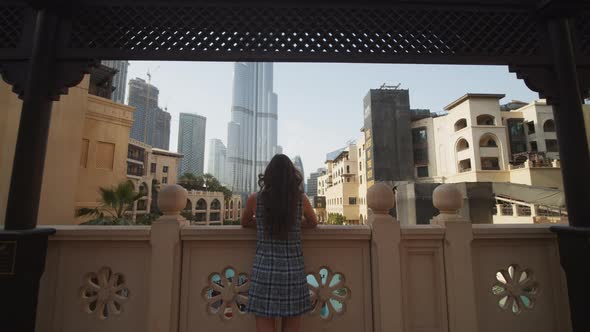 Woman Enjoying a View of Burj Khalifa in Dubai From the Balcony alt