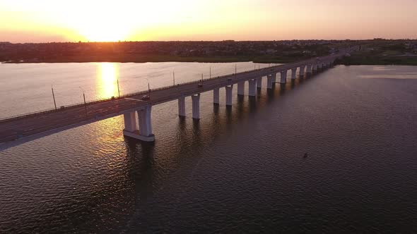 Aerial Shot of a Lengthy Bridge Covering the Dnipro at Splendid Sunset in Summer