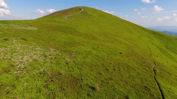 Aerial flight over green hill mountains. FPV Dynamic drone shot