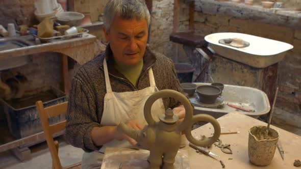 Potter working on clay sculpture alt