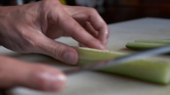 Close Up View of Removing Inedible Parts and Cutting Cucumber Into Thin Slices alt
