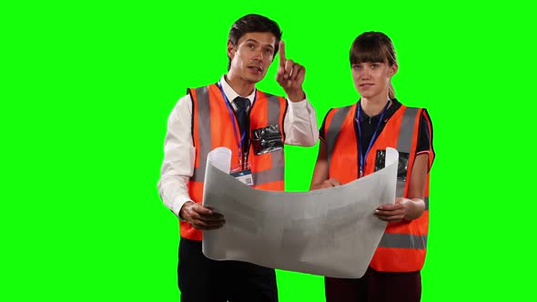 Front view of a site workers looking at a site map with green screen alt
