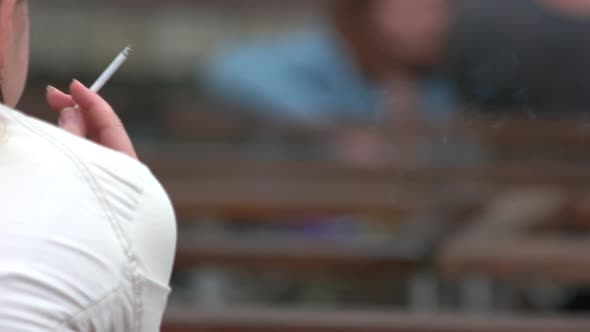 Woman Holding Burning Cigarette in Hand alt