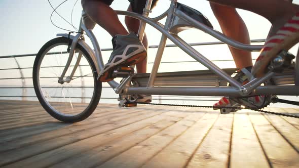 Portrait of a Mixed Race Couple Riding on Tandem Bicycle Outdoors Near the Sea Slow Motion Close Up alt