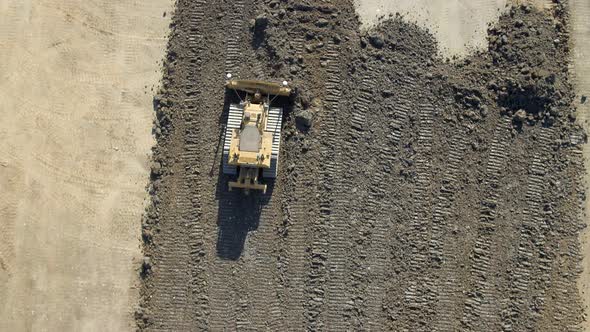 A Bulldozer Moving Earth to Flatten it for Construction alt