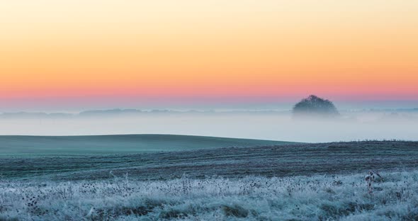 Hazy Morning Fog with Frozen Meadows Colorful Morning Sky and Slowly Moving Fog in the Fields