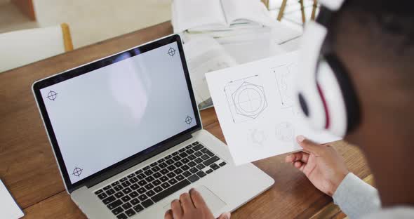 African american man wearing headphones and using a laptop with copy space alt